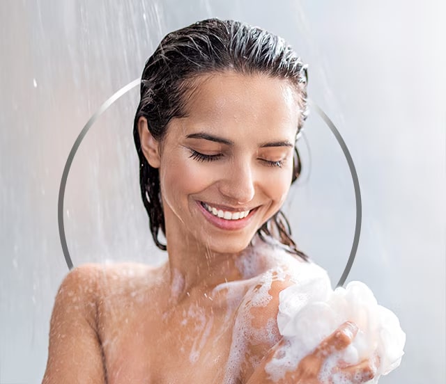 Young smiling woman taking a shower