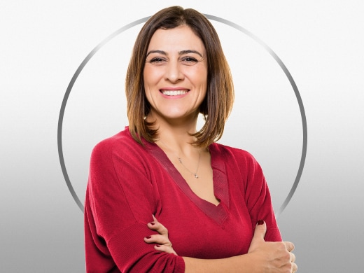 Smiling mature woman wearing red blouse and standing confidently, happy after Canesten vaginal dryness treatment